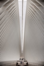 Interior of a minimalist industrial hangar with subtle Italian flag colors and modern urban design.