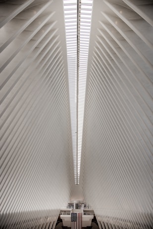 Interior of a minimalist industrial hangar with subtle Italian flag colors and modern urban design.