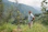 a man standing in a field next to a tree