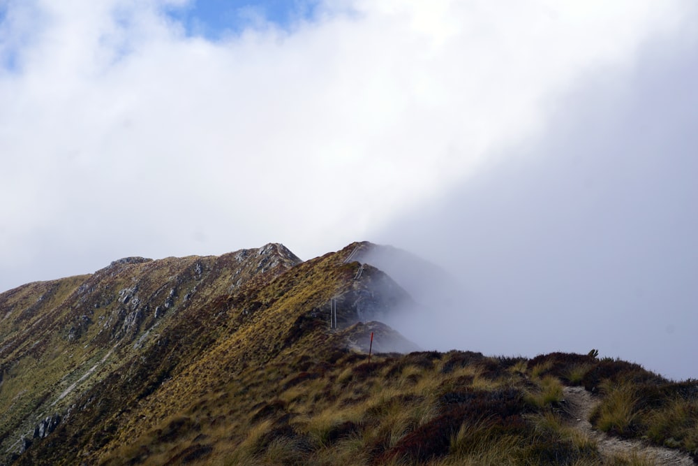 a very tall mountain with some clouds in the sky