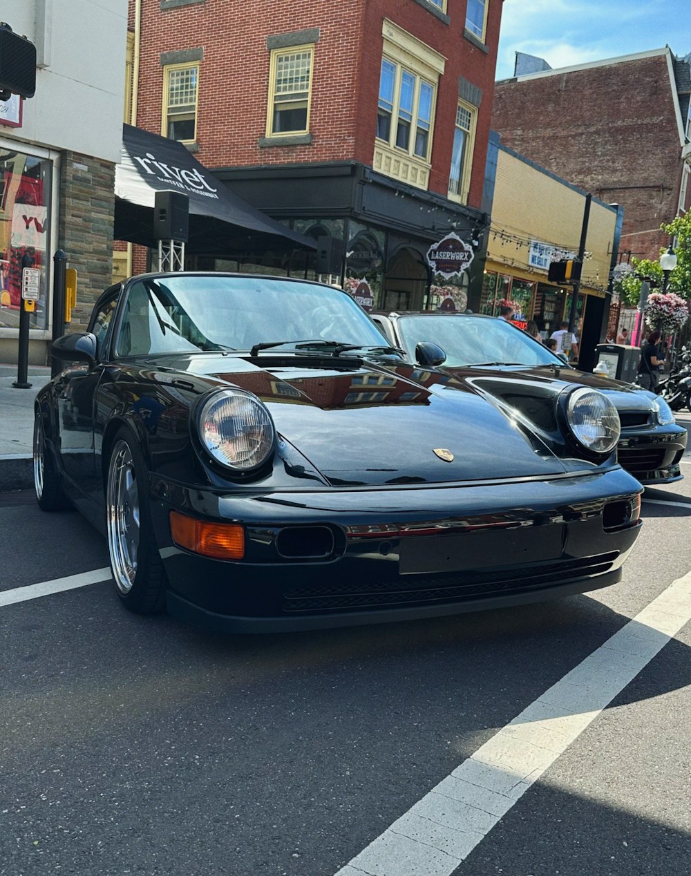 a black porsche parked on the side of the road