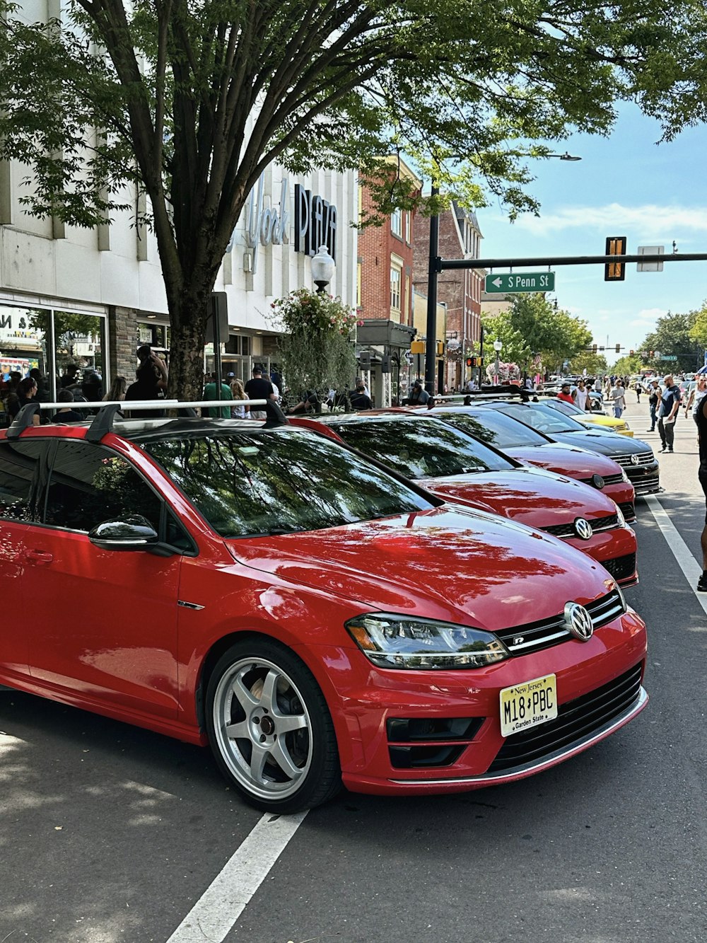 a row of red cars parked on the side of a road