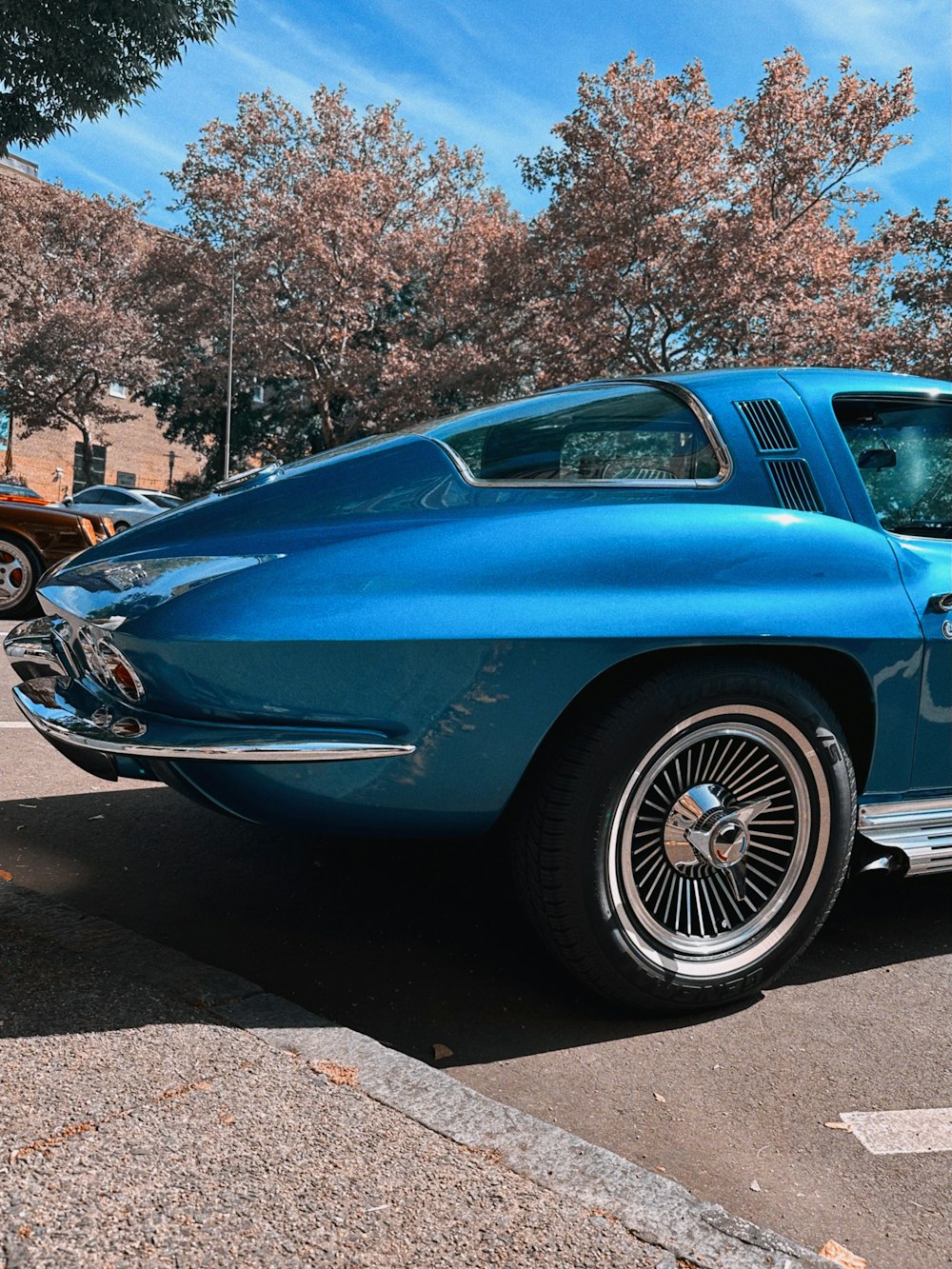 a blue classic car parked in a parking lot