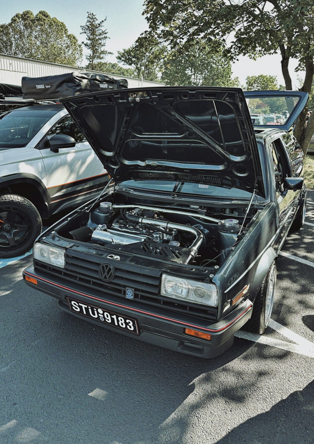 a car with its hood open in a parking lot