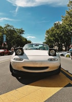 a white sports car parked on the side of the road