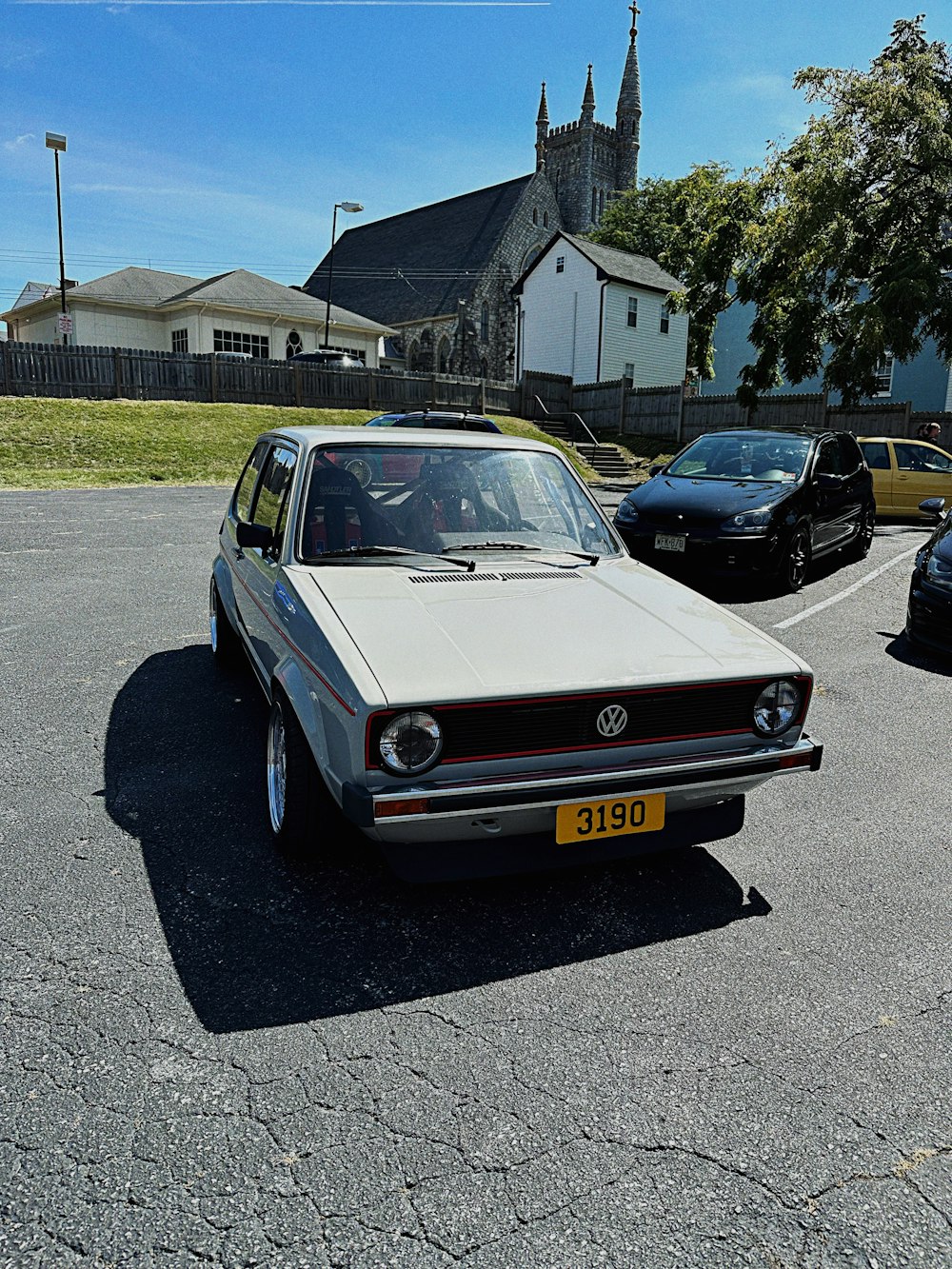 a white car parked in a parking lot next to a church