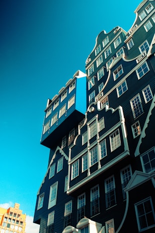 A newly built blue-painted overkapping attached to a cozy Zeeland home on a sunny day.