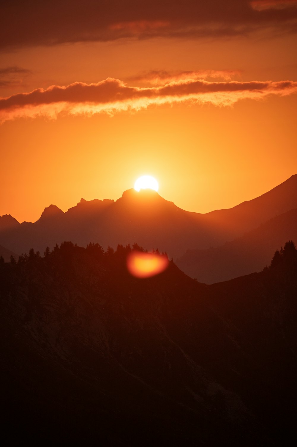 the sun is setting over a mountain range