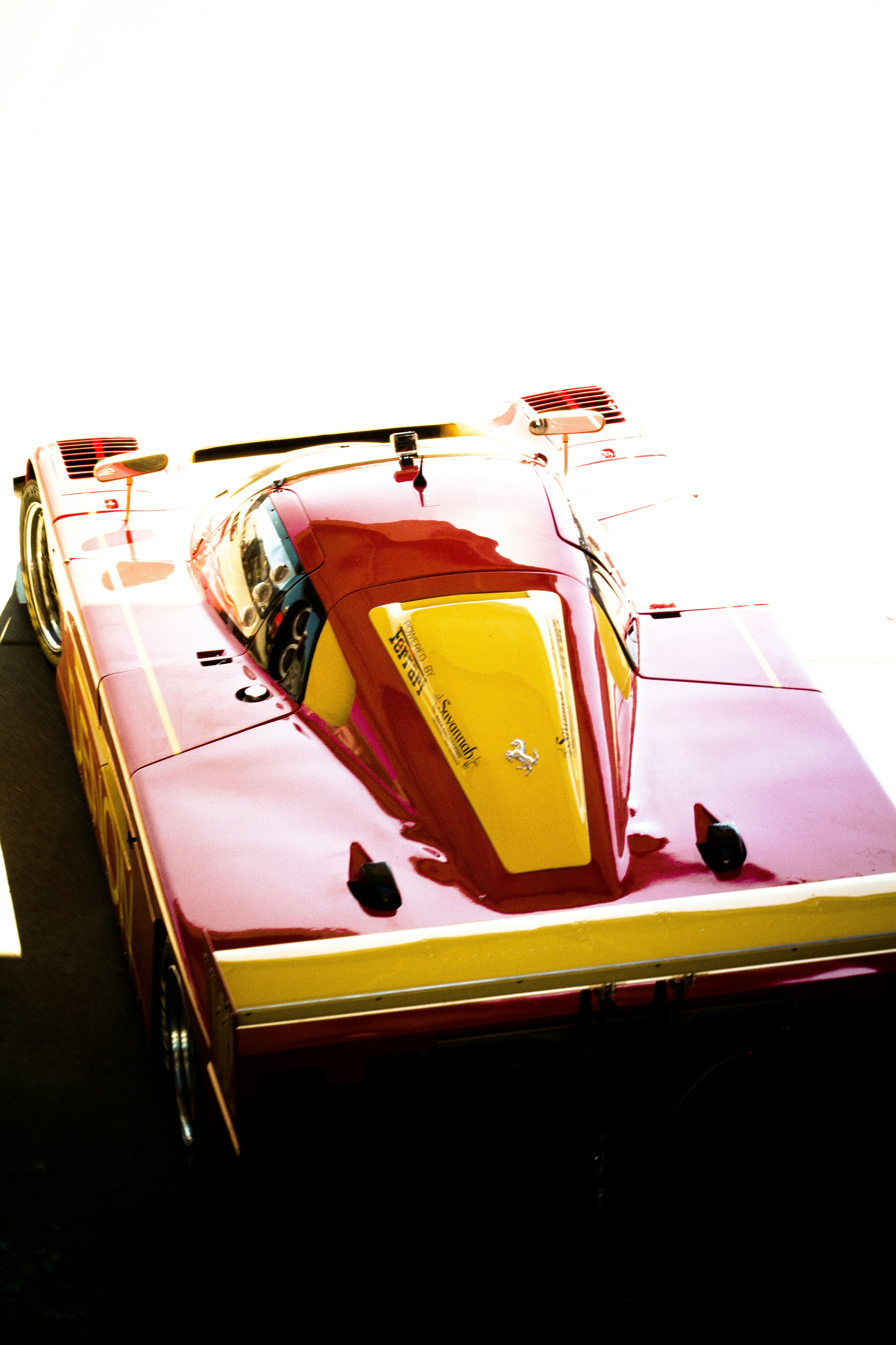 a red and yellow car is parked on the street