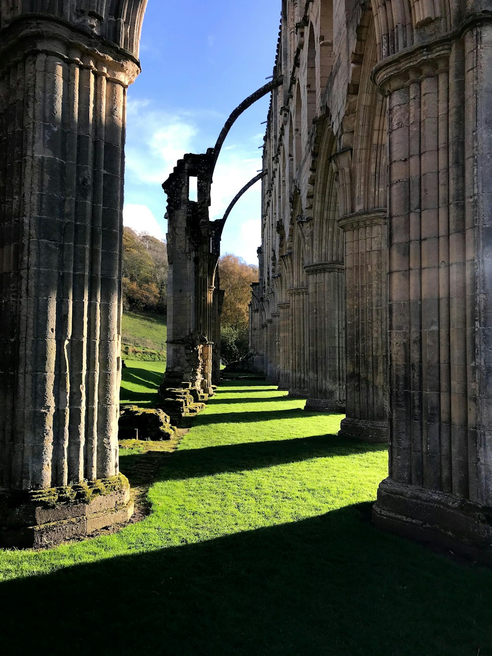 a row of stone pillars in a grassy area