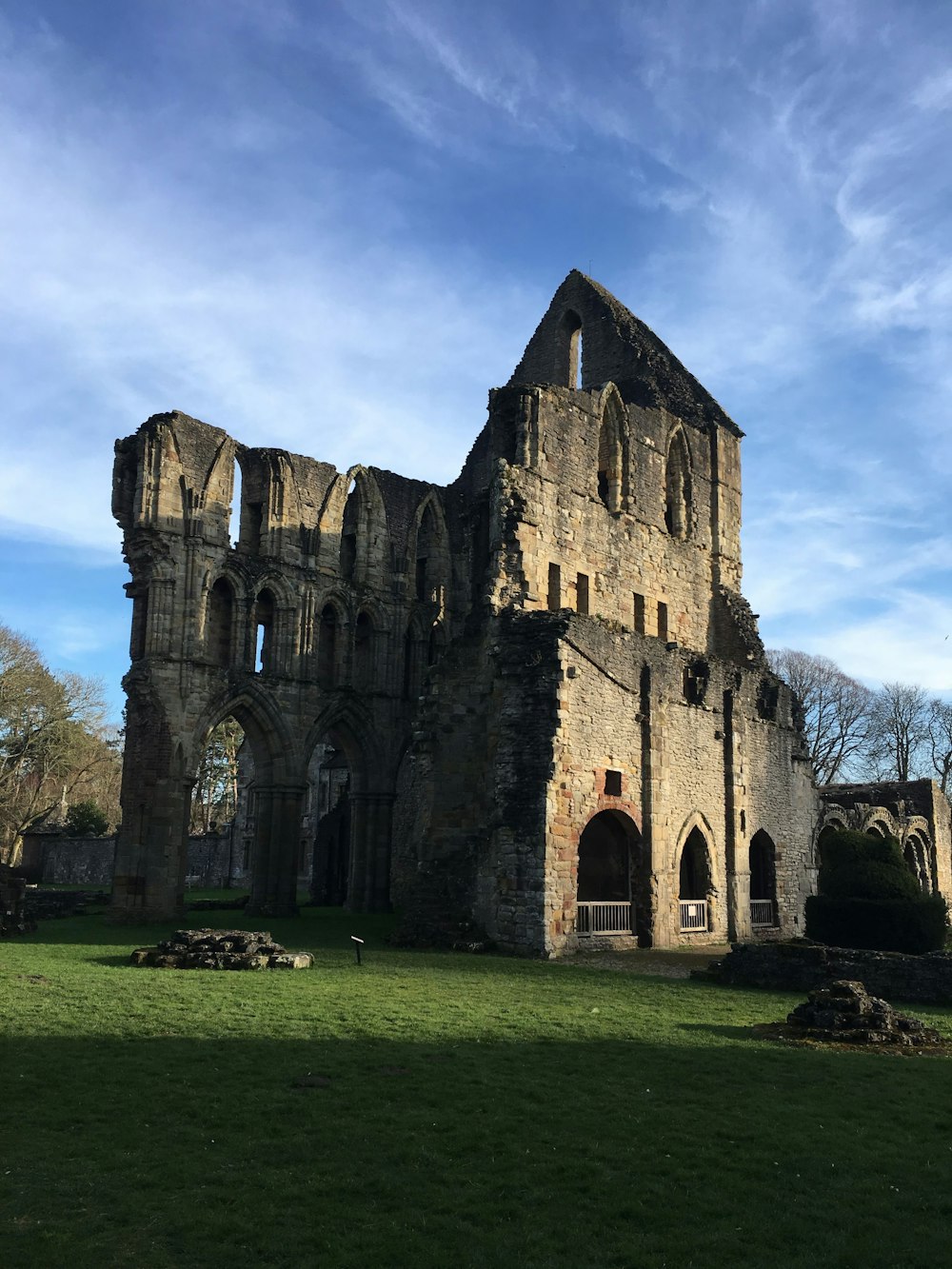 a large stone building sitting on top of a lush green field