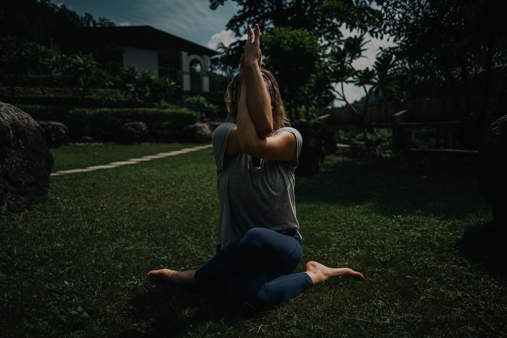 a woman sitting on the ground with her hands in the air