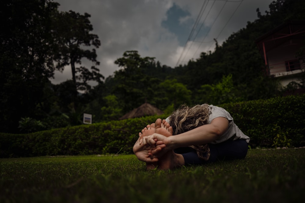 a woman sitting in the grass with her hands on her face