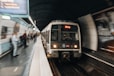 a train traveling through a train station next to a crowd of people