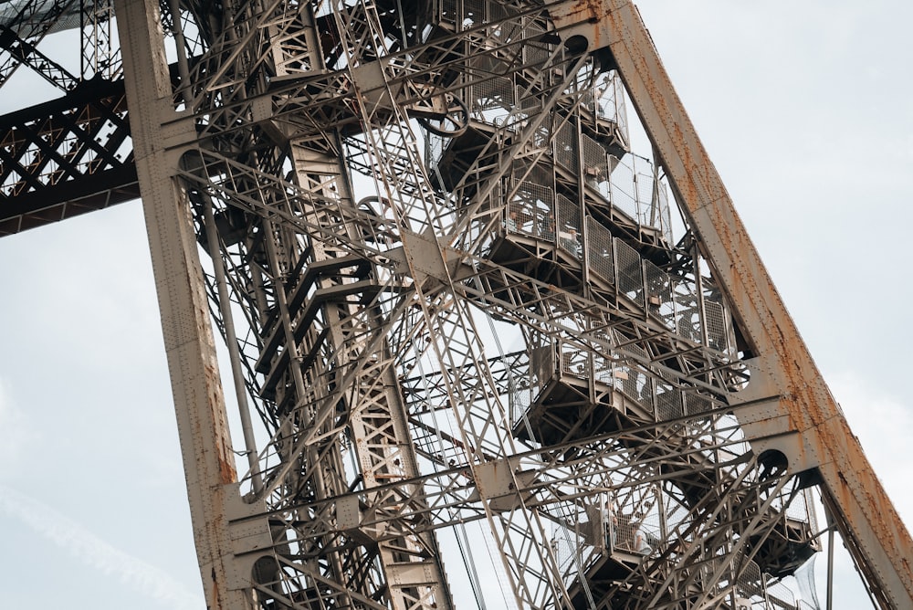 a very tall metal structure with a clock on it's side