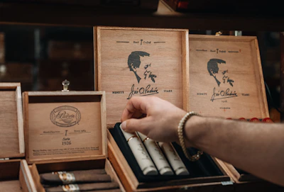 Close-up of hands selecting premium tobacco products on a wooden counter