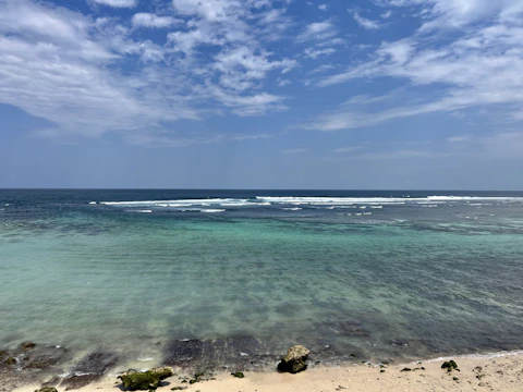 A serene coastal scene with deep blue ocean and clear sky.