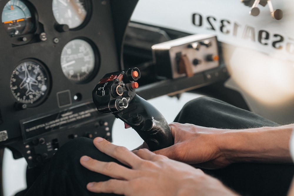 a person holding a gun in front of a cockpit of a plane