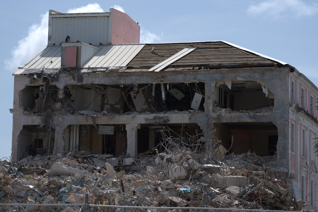 a building that has been demolished with a fence in front of it, Abandon house