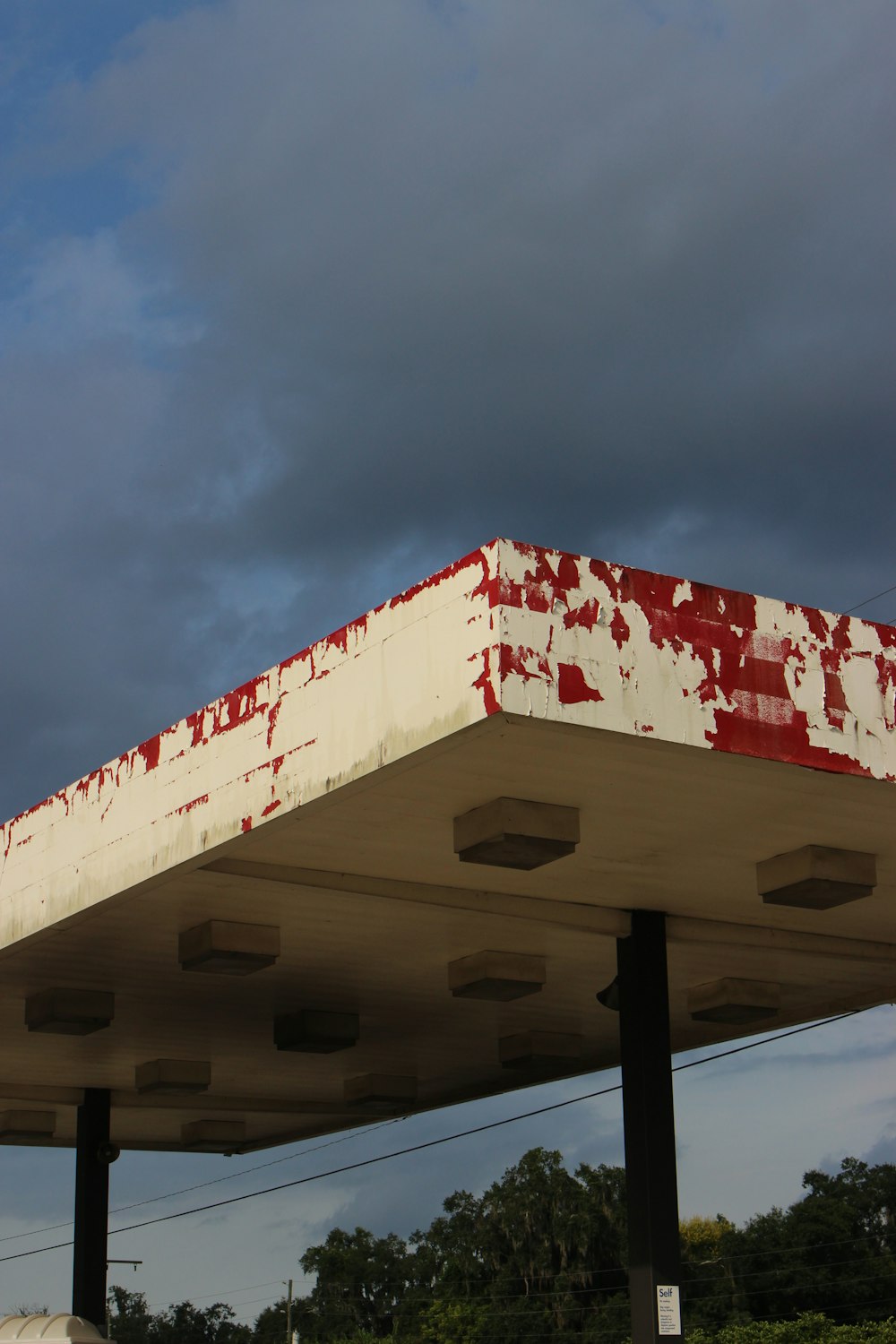 un techo de gasolinera pintado de rojo y blanco