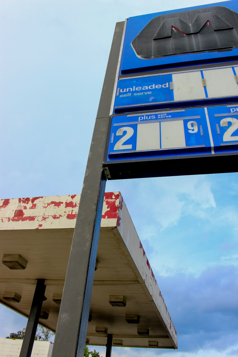 Un letrero de gasolinera con un fondo de cielo