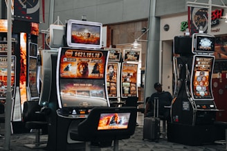 A technician servicing a slot machine inside a lively restaurant.
