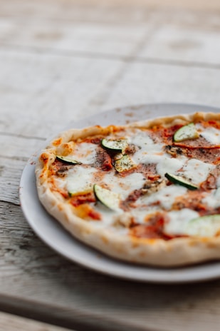 A close-up of a freshly baked pizza topped with vibrant vegetables and melted cheese.