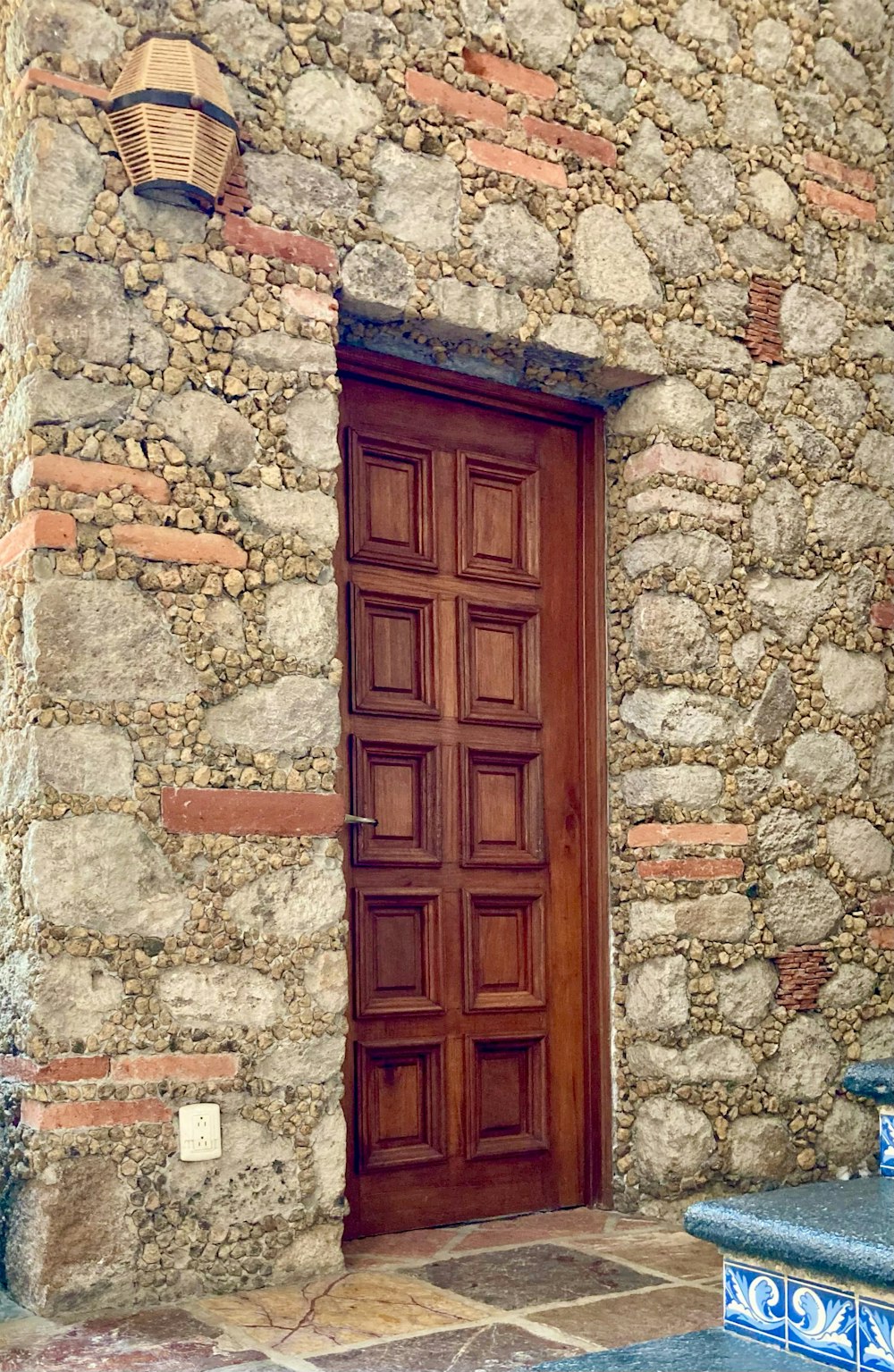 a stone building with a wooden door and bench