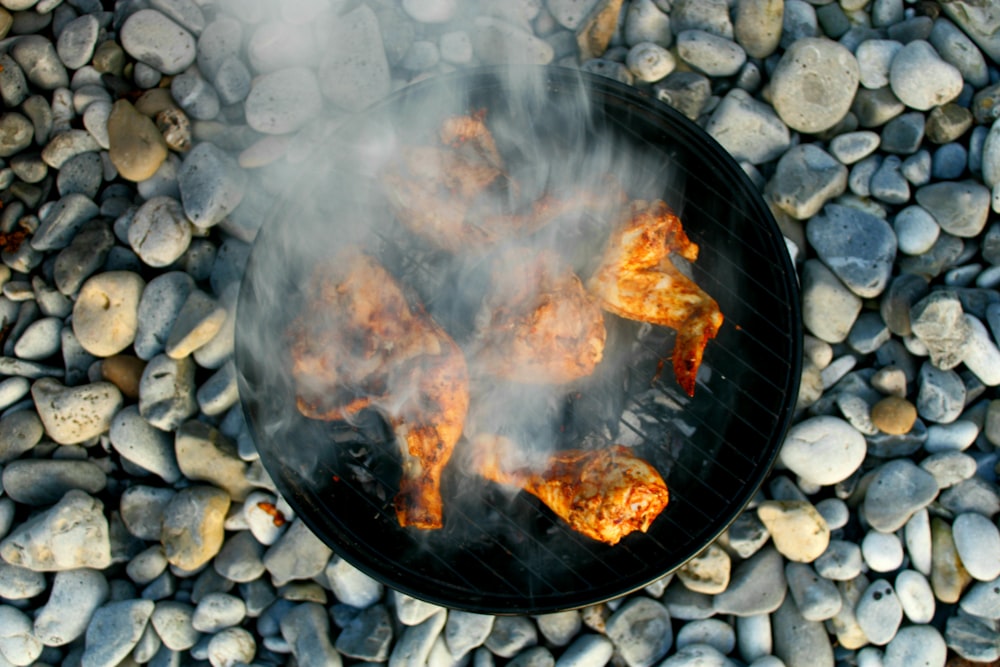 a bbq with some food cooking on top of it