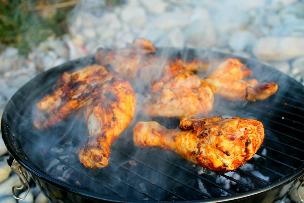 a close up of a grill with chicken on it