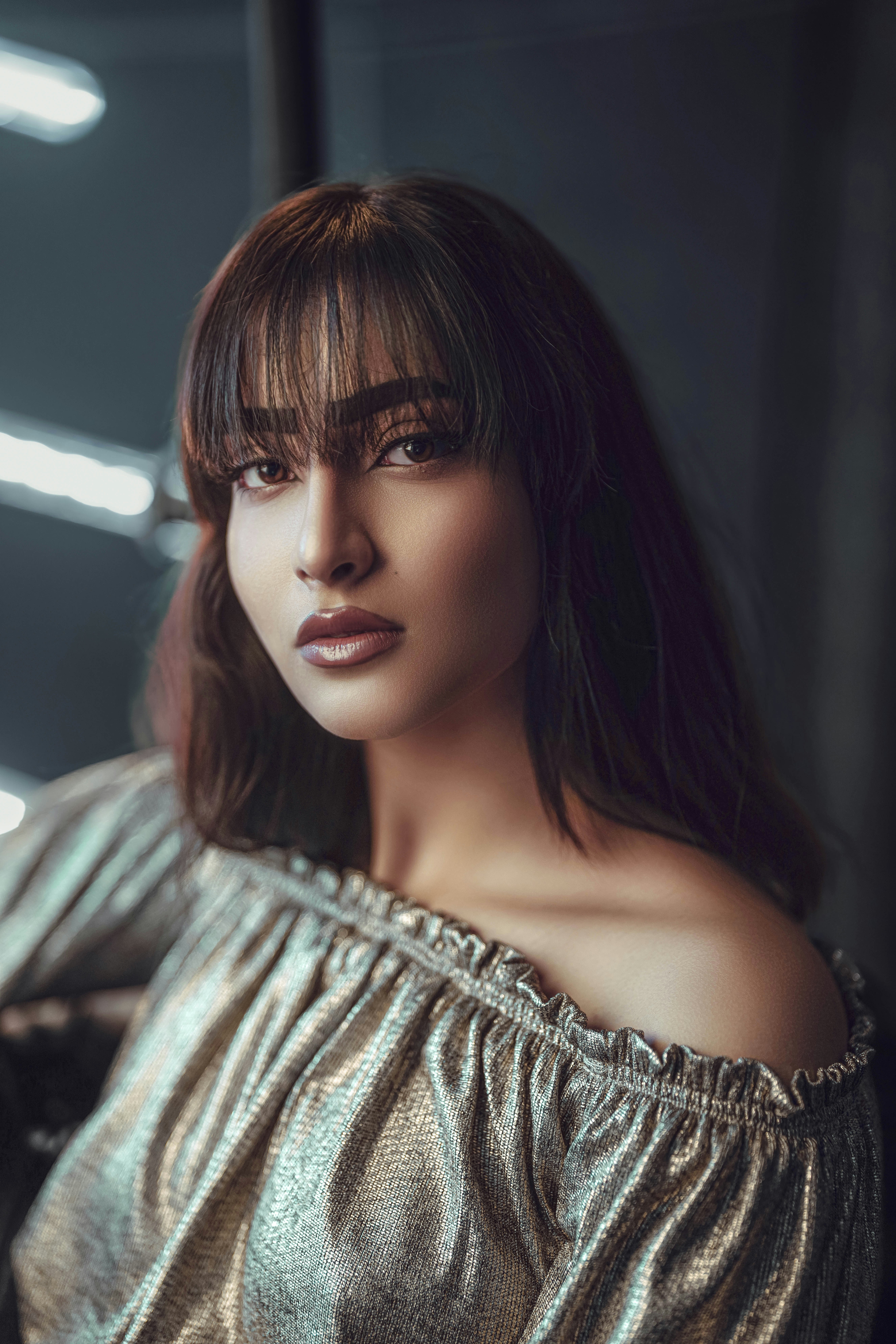 a close up of a person wearing a gold top