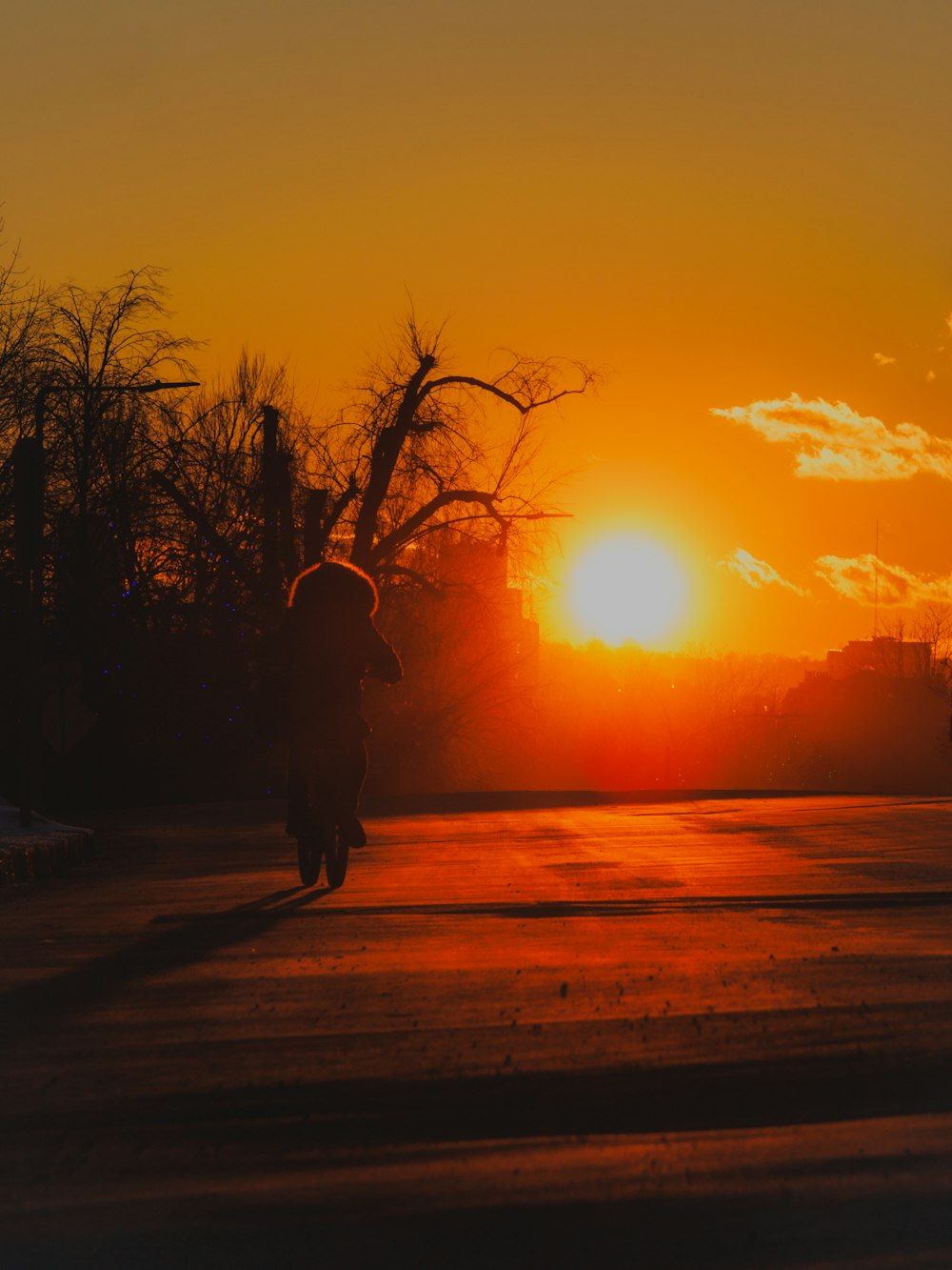 a person walking down a street at sunset