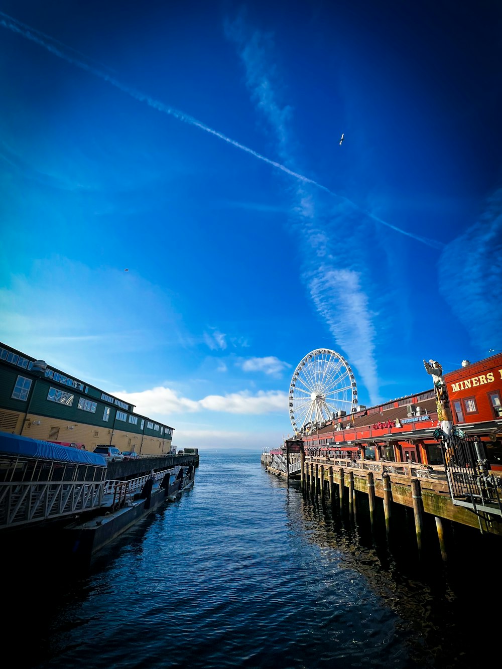 a pier with a ferris wheel and a ferris wheel in the distance