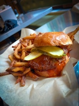 A juicy burger with crispy fries on the side, served on a rustic wooden table.