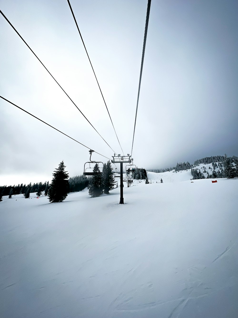 ein Skilift, der über eine schneebedeckte Skipiste führt