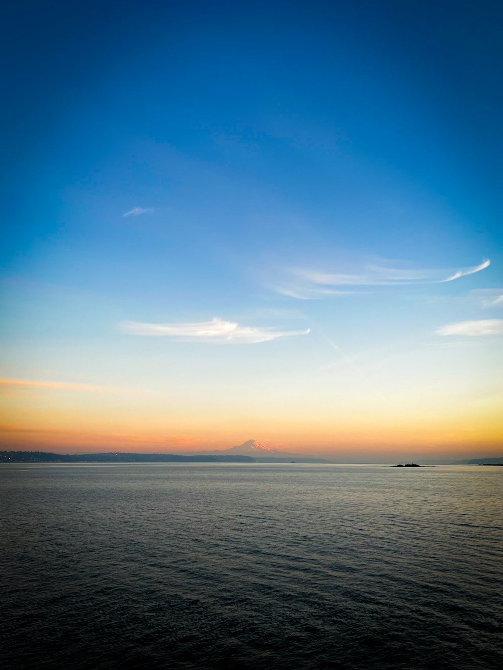 a large body of water with a sky in the background