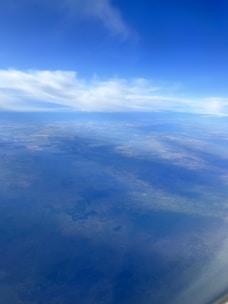 A satellite orbiting Earth, capturing environmental data over lush green fields.