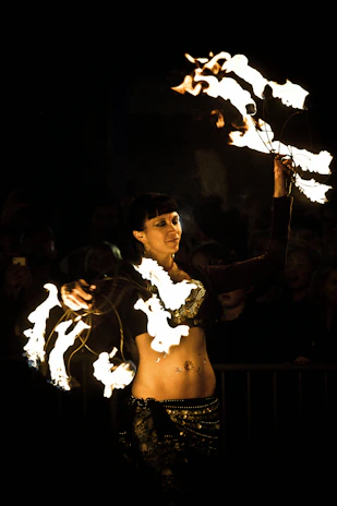 A sleek cyberpunk performer spinning LED poi with glowing neon trails in a dark urban setting.