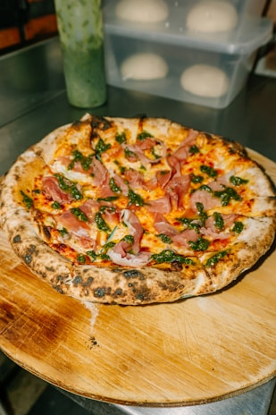 a pizza sitting on top of a wooden cutting board