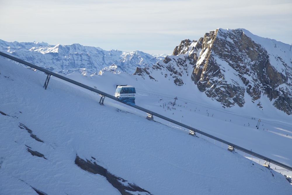 a blue bus driving down a snow covered road