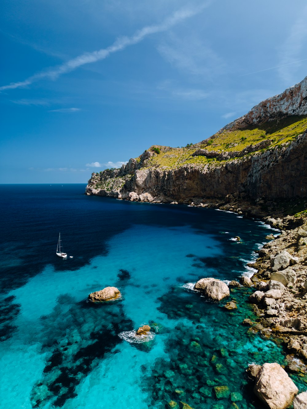 a boat is in the water near a rocky shore