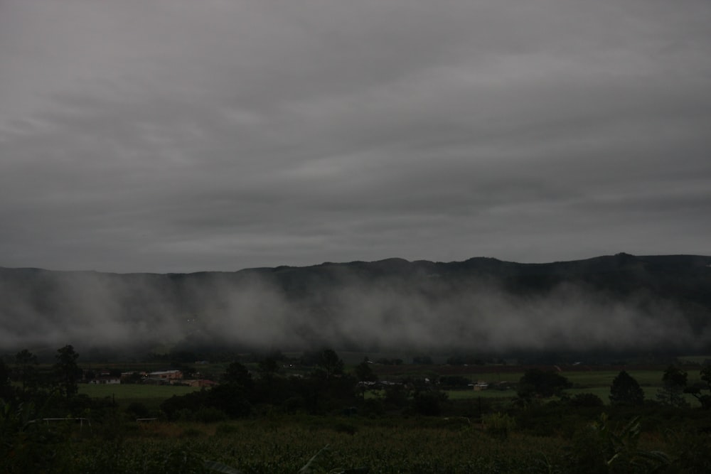 a foggy landscape with mountains in the distance