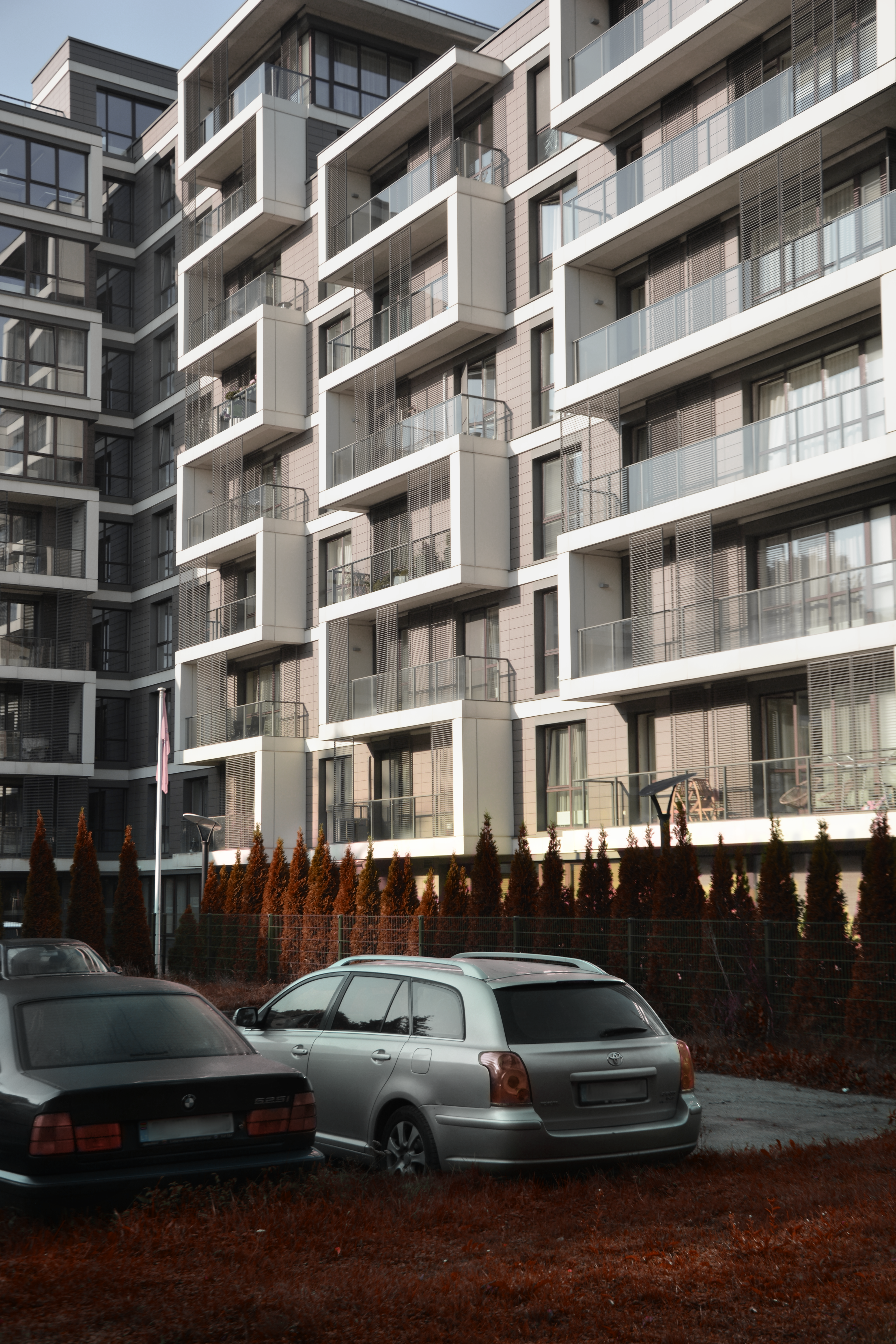 Quelques voitures garées devant un grand immeuble