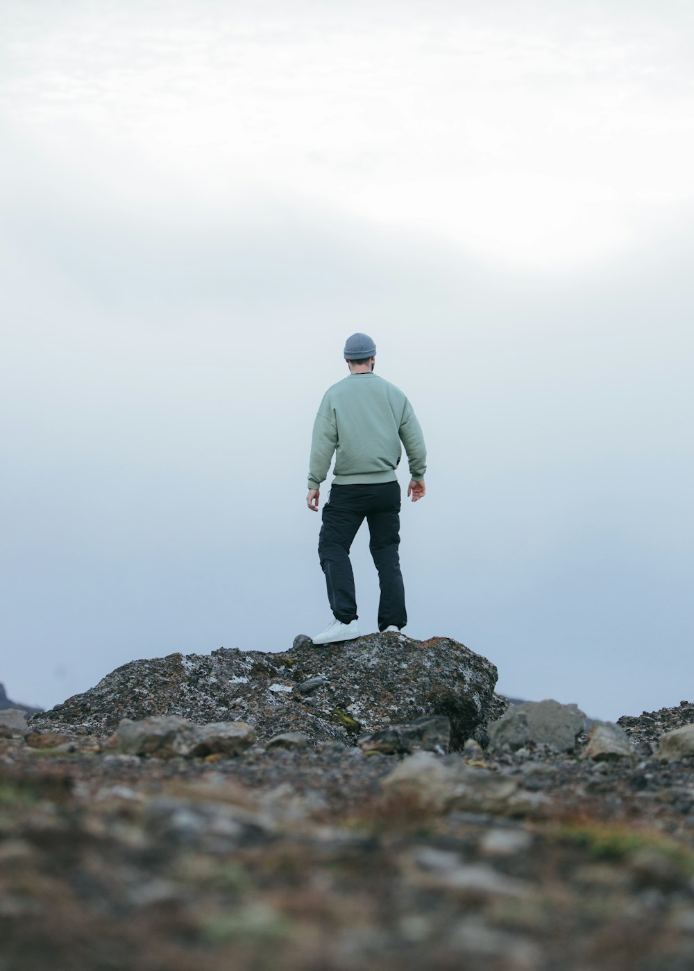 a man standing on top of a rocky hill
