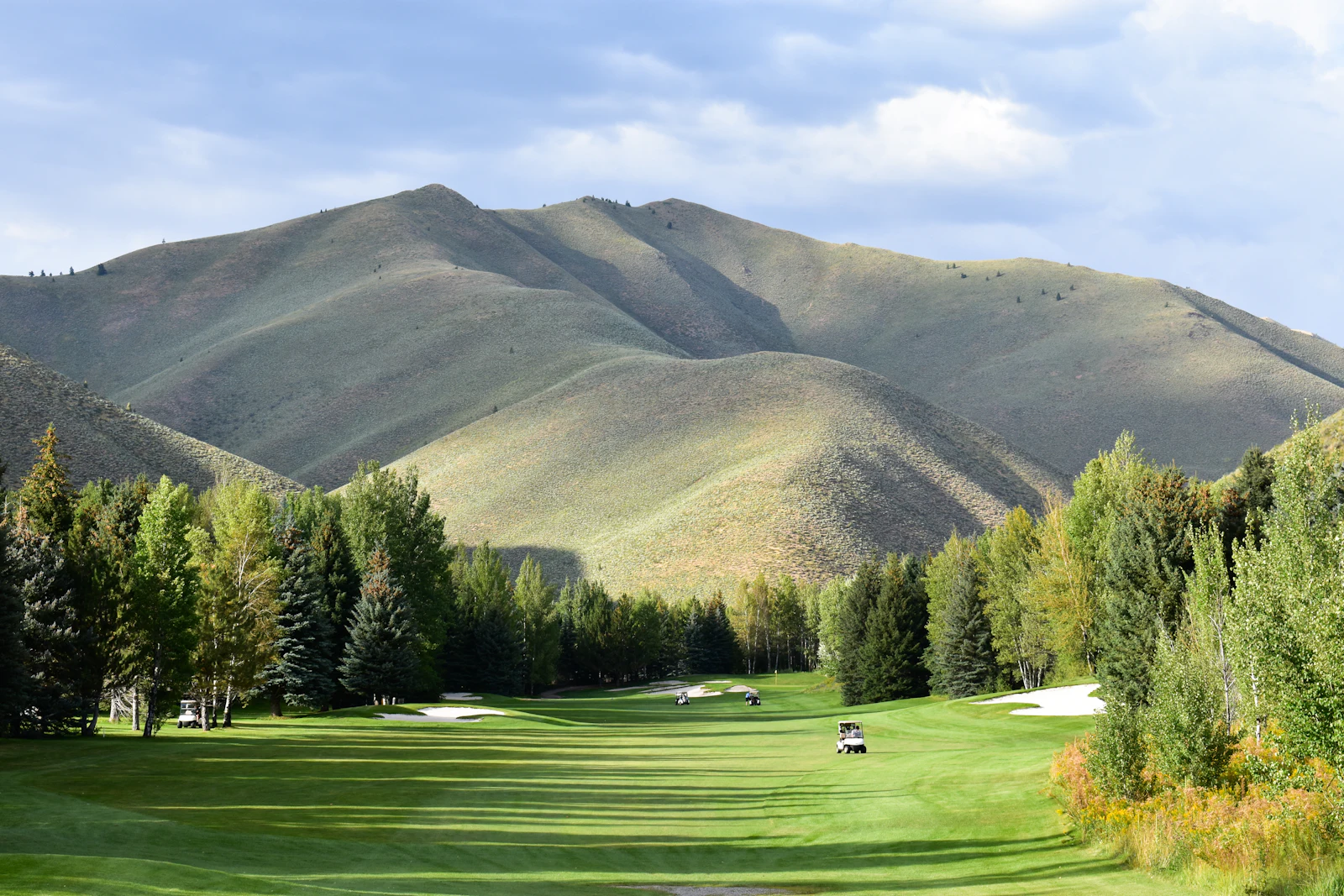 Parcours de golf au pied de montagnes (image d'illustration)