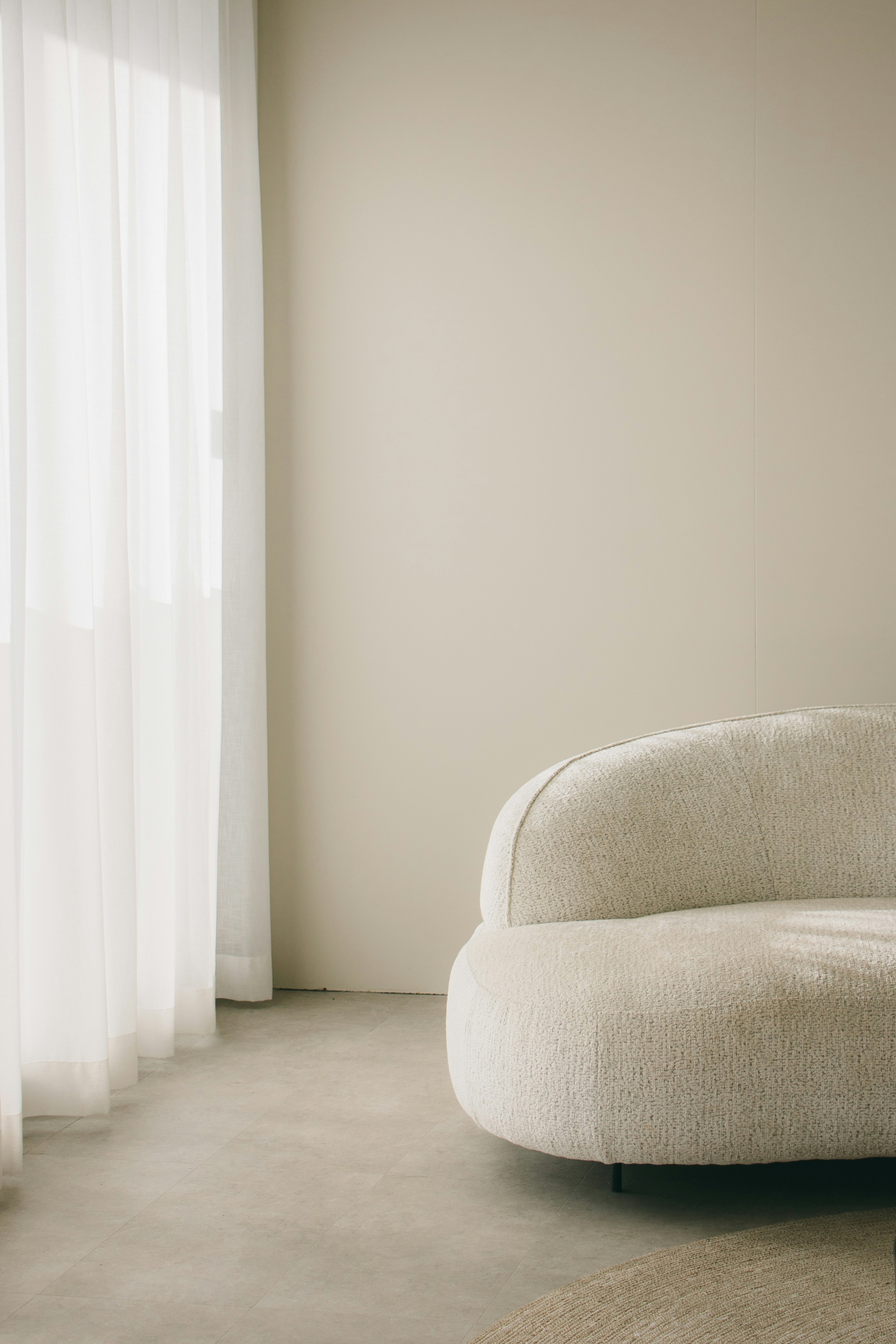 a white couch sitting in a living room next to a window