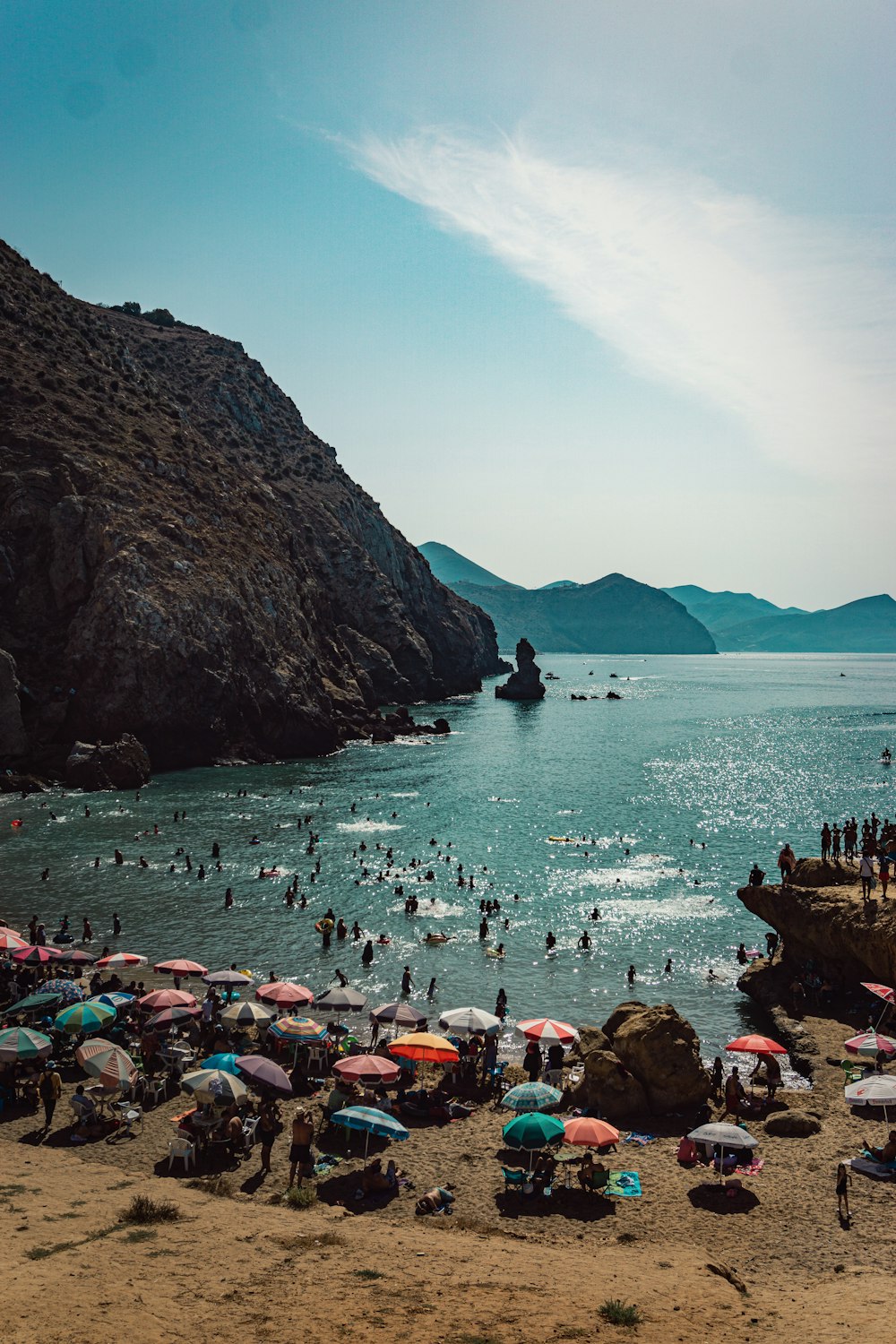 a group of people on a beach with umbrellas