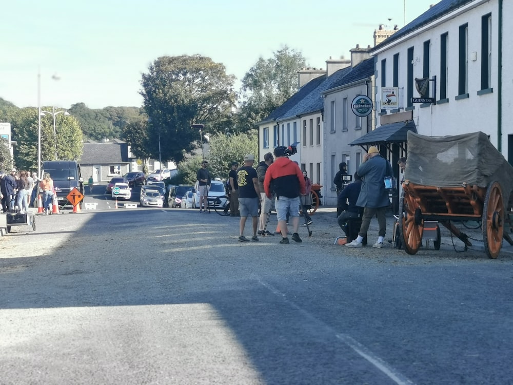 a group of people standing on the side of a road