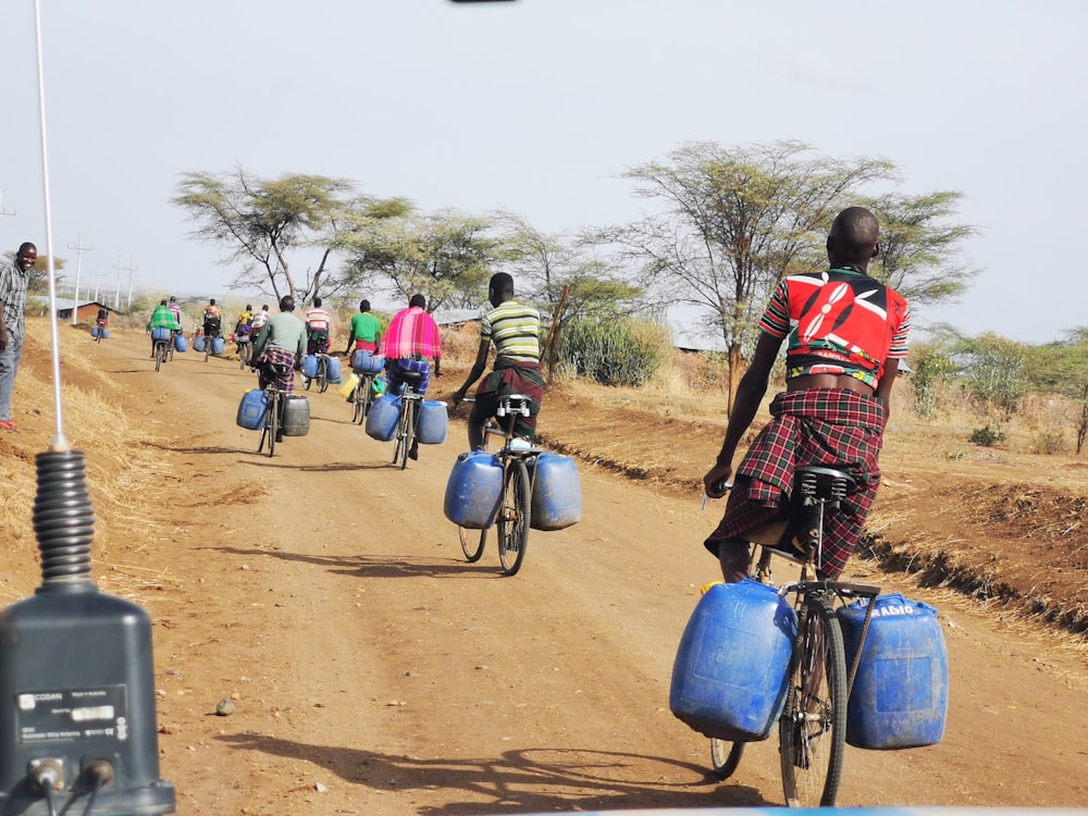 a group of people riding bikes down a dirt road