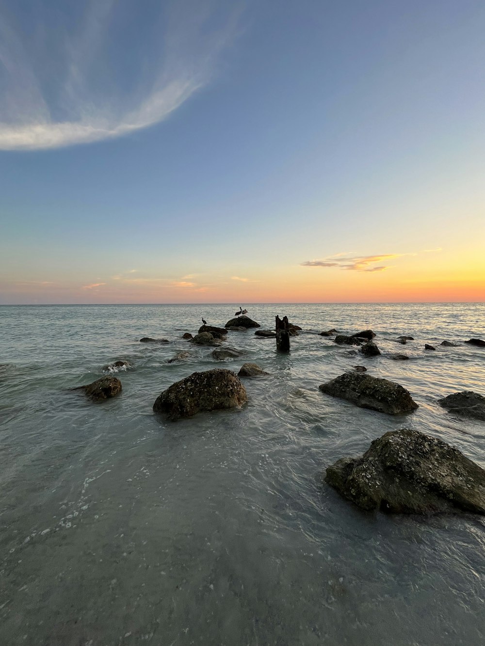 a group of rocks sitting in the middle of a body of water